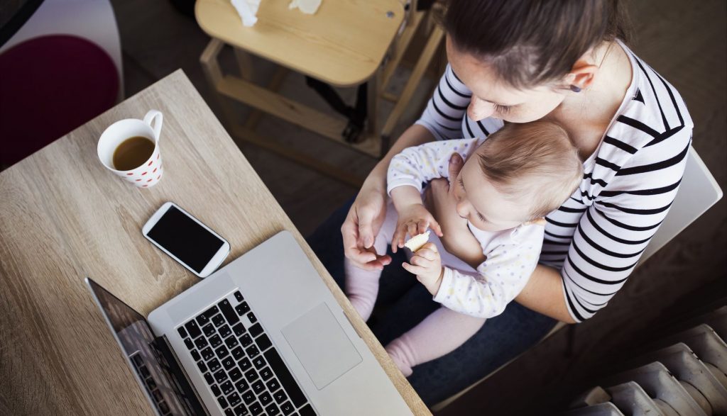 young mother in home office with computer and her daugher